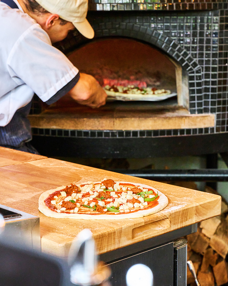 Chef preparing pizza in oven
