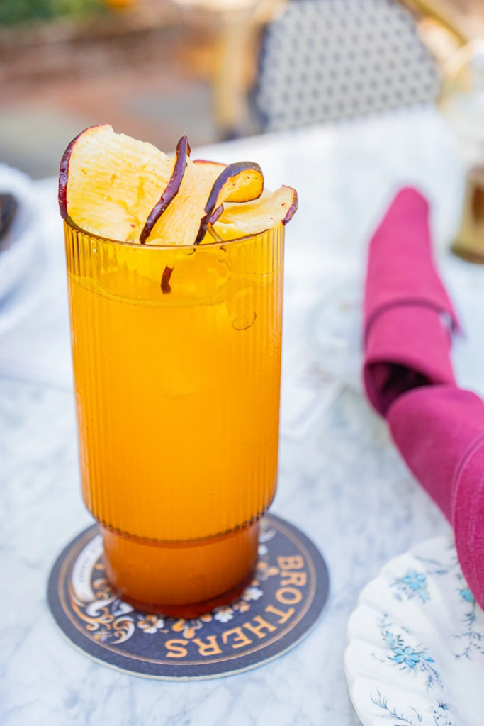 Orange drink with apple slices garnish