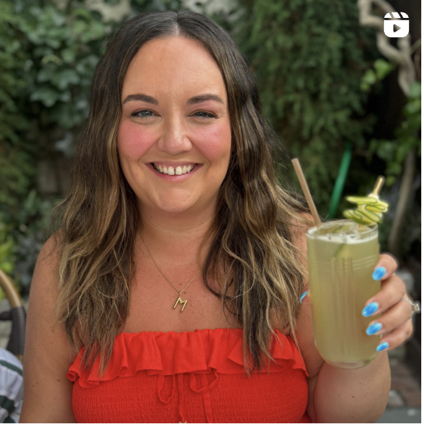 Woman holding a drink outdoors.